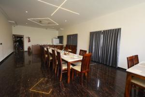 a dining room with a long table and chairs at Corbett Caves in Rāmnagar