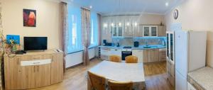 a large kitchen with a table and a refrigerator at Residenz Emilia in Mariánské Lázně
