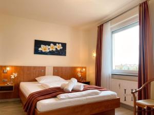a hotel room with a bed with a window at Hotel Falk in Bremen