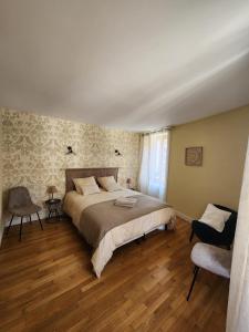 a bedroom with a large bed and a chair at La Tour Cicon in Salins-les-Bains