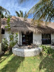a house with a thatch roof and a round patio at Mayan Mittoz in Holbox Island