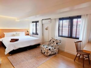 a bedroom with a bed and a chair and windows at Baan Rak BTS phromphong Emsphere in Bangkok