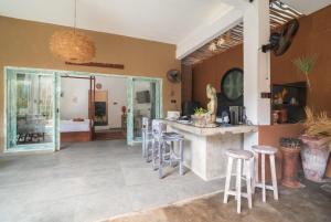 a kitchen with a counter and stools in a room at Jellyfish2 2BR for Groups, 5 Min to Thomas Beach in Uluwatu +12 photos