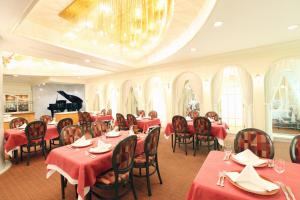 Nagaoka Grand Hotel في ناغاوكا: مطعم بالطاولات الحمراء والكراسي والبيانو