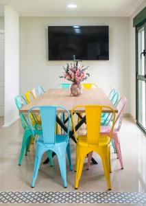 a table with colorful chairs and a vase of flowers on it at Pensión Casa Rego Sarria in Sarria