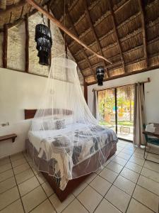 a bedroom with a bed with mosquito net at Mayan Mittoz in Holbox Island +44 photos