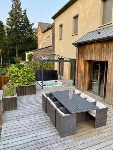 a wooden deck with a table and a gazebo at Tardif in Vitré