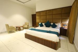a bedroom with a large bed with a large headboard at Corbett Caves in Rāmnagar +13 photos