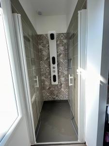 a bathroom with a shower with a speaker on the wall at Tardif in Vitré +27 photos