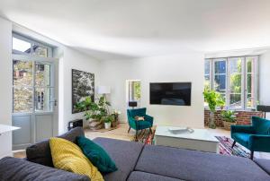 a living room with a gray couch and blue chairs at Moulin in Vitré