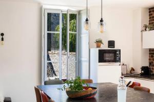 a kitchen with a table and a window in a room at Moulin in Vitré
