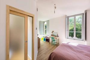 a bedroom with a bed and a desk and windows at Moulin in Vitré