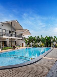 a swimming pool in front of a building at Dallas Beach Resorts Ashvem Beach in Mandrem