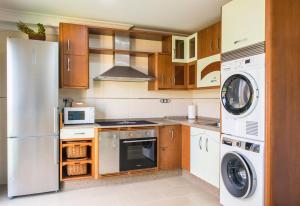 a kitchen with a refrigerator and a washer and dryer at Pensión Casa Rego Sarria in Sarria