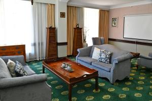 ein Wohnzimmer mit zwei Sofas und einem Bildschirm in der Unterkunft The Balmoral - Halaal in Durban
