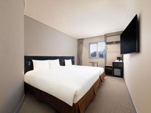 a hotel room with a large bed and a television at ibis Ambassador Seoul Insadong-Newly renovated in 2025 in Seoul