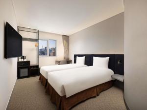 a hotel room with two beds and a mirror at ibis Ambassador Seoul Insadong-Newly renovated in 2025 in Seoul +97 photos