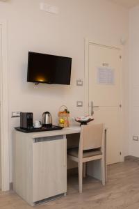 a kitchen with a desk with a microwave and a door at B&B Domus Vettii in Pompei
