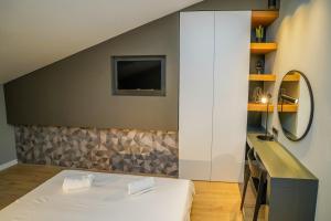 a bedroom with a bed and a mirror and a sink at Seaview Villa Rajmond in Podstrana