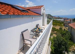 a balcony with two chairs and a table on it at Seaview Villa Rajmond in Podstrana