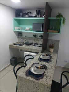 a kitchen with a table with two chairs and a sink at Ocean Flat Tambaú in João Pessoa