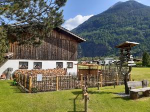 a building with a fence in front of a mountain at Landsitz im Reitle in Längenfeld +23 photos