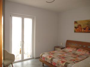 a bedroom with a bed and a sliding glass door at Anagnina Apartment Capistrano in Rome
