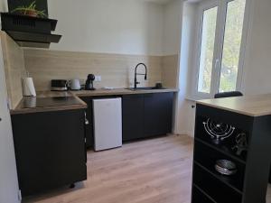 a kitchen with a sink and a white refrigerator at L'hyère in Carhaix-Plouguer
