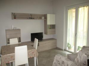 a kitchen and living room with a table and a television at Anagnina Apartment Capistrano in Rome