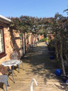 a white bird walking past a patio with tables and chairs at The Barn Bed and Breakfast in Liverpool