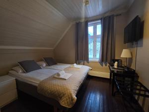 a bedroom with a bed and a desk and a window at Stryn Kaffebar & Vertshus in Stryn +48 photos
