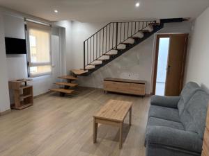 a living room with a couch and a staircase at Hostal Mallorquines in Riudarenes
