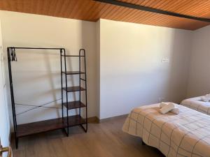 a room with a bedroom with a bed and a shelf at Hostal Mallorquines in Riudarenes