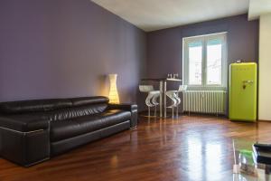PrimoPiano - Orombelli في ميلانو: غرفة معيشة مع أريكة جلدية سوداء وطاولة