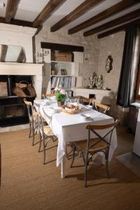 a dining room with a white table and chairs at Longère de charme en pleine nature in Chillac