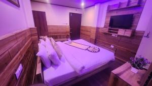 a bedroom with a bed and a television in it at Pradhan Hotel Mirik Lake Side in Mirik