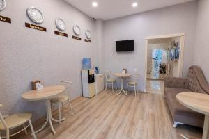 Ein Wartezimmer mit zwei Tischen und einem Kühlschrank in der Unterkunft MidCity Hotel in Baku