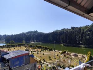 a view of a park and a body of water at Pradhan Hotel Mirik Lake Side in Mirik