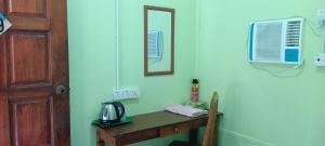 a room with a table and a mirror and a door at Cheers Garden Chalet in Kampung Tekek