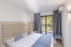a hotel room with a bed and a balcony at Apartamentos Casa Vida in Santa Ponsa +35 photos