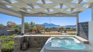 a hot tub on a patio with a view of the ocean at Aelia Suites in Adamantas