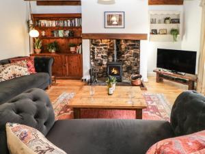 a living room with couches and a fireplace at Englewood Cottage in Hexham
