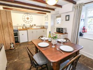 a kitchen with a wooden table with chairs and a dining room at Englewood Cottage in Hexham