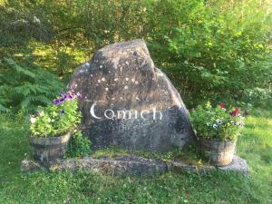 a sign for a garden on a rock with flowers at The Tomich Hotel in Inverness