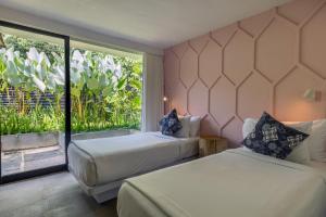 two beds in a room with a large window at Origin Uluwatu in Uluwatu +62 photos