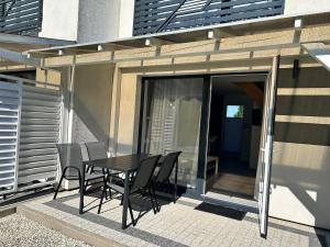 a patio with a table and chairs on the side of a building at Villa Over Lake in Mielno