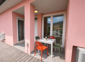 a pink house with a table and chairs on a balcony at Casa Sveva al Cavo in Cavo