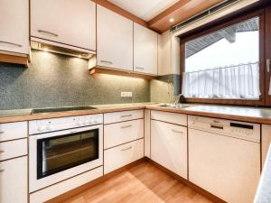 a kitchen with white cabinets and a window at Ferienwohnung Felder in Bürs