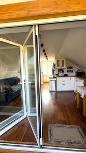 a living room with sliding glass doors and a kitchen at Laki house in Jasień