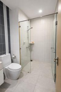 a bathroom with a toilet and a glass shower at NexStay Bangkok Appartment in Bangkok +8 photos